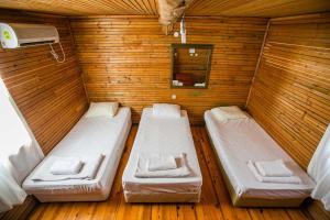 Duas camas num pequeno quarto com paredes de madeira em Kadir's Family House em Olympos