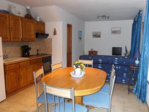 cocina y comedor con mesa de madera y sillas en Maison de Pecheur, en Port-en-Bessin-Huppain
