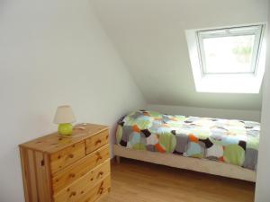 a bedroom with a bed and a dresser and a window at Maison de Pecheur in Port-en-Bessin-Huppain