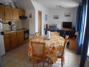 a kitchen with a table with chairs and a table cloth at Maison de Pecheur in Port-en-Bessin-Huppain