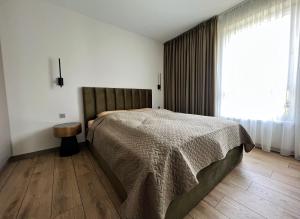 a bedroom with a bed and a large window at Cozy family apartment near the old town in Klaipėda