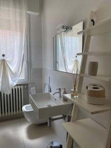 Baño blanco con aseo y lavamanos en Casetta Mia - Holiday Family House, en Santarcangelo di Romagna
