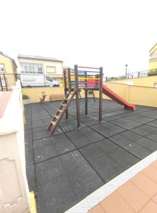 un parco giochi con scivolo sul tetto di Apartamento Tamarisco a Foz