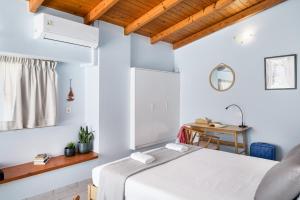 una camera bianca con letto e scrivania di DAPHNE lovely loft in the heart of Rethymno a Rethymno