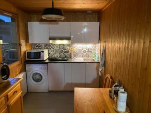 a kitchen with a stove and a microwave at Petit chalet 40 m2 en Ubaye BARCELONNETTE in Barcelonnette