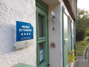 una señal en el lateral de un edificio con ventana en Gîte 4 étoiles La Belle Eau Calme, en Futeau