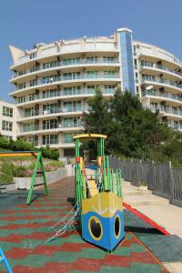 a playground in front of a large building at Silver Beach Apart Complex in Byala