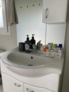 a white sink in a bathroom with bottles on it at Mobile Home L&L in Drage