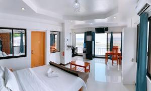 奧斯洛布的住宿－LUNA OSLOB TRAVELLERS INN - Beach Front，一间带大床的卧室和一间餐厅