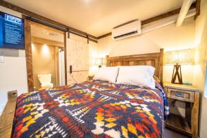 a bedroom with a bed with a colorful blanket at St. Elmo Hotel in Ouray
