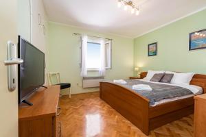 a bedroom with a bed and a flat screen tv at CENTRO apartment in Zadar