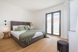 a white bedroom with a bed and a large window at Villa Cvita east in Primošten +22 photos