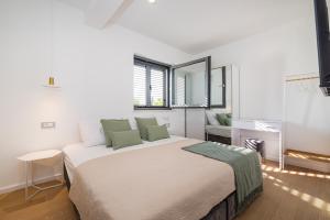 sypialnia z dużym białym łóżkiem z zielonymi poduszkami w obiekcie Vila Cvita w Primošten