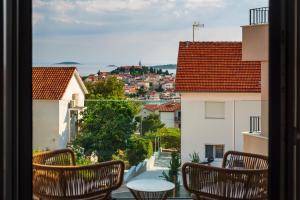 ein Balkon mit Stühlen und Blick auf die Stadt in der Unterkunft Vila Cvita in Primošten