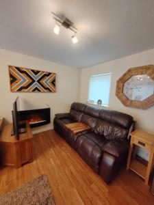 uma sala de estar com um sofá de couro e uma lareira em Castle View Guest House em Harlech