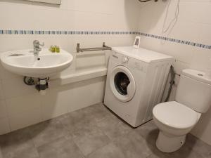 y baño con lavadora y lavamanos. en Apartamento bajo en Mentidero, en Cádiz