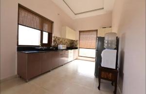 a large kitchen with a sink and a counter at Farm Stay in Neemrana I 3 BHK with Pool & Chef I Close to Nature - Poshpad in Behror