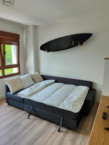 - un lit dans un dortoir avec une planche de surf sur le mur dans l'établissement Digital Nomad Paradise - Garaje/PC monitor, à Salinas