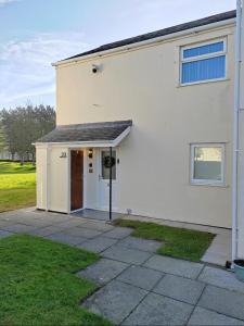 a white house with a door and a yard at Castle View Guest House in Harlech