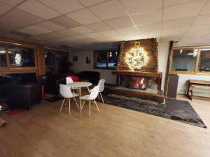 un soggiorno con camino, tavolo e sedie di Chalet 4 pers. Piscine et literie toute neuve. a Puy-Saint-Vincent