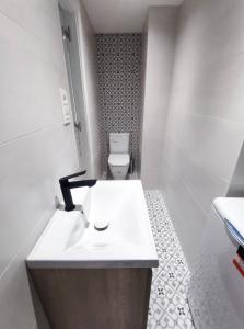 La salle de bains est pourvue d'un lavabo blanc et de toilettes. dans l'établissement Digital Nomad Paradise - Garaje/PC monitor, à Salinas