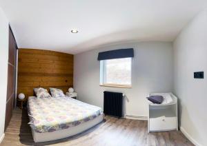 1 dormitorio con cama y ventana en Appartement au pied des pistes, en Besse-et-Saint-Anastaise