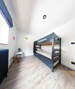1 dormitorio con litera y suelo de madera en Appartement au pied des pistes, en Besse-et-Saint-Anastaise