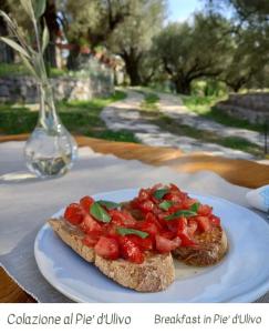 un trozo de pan con tomates en un plato en Oikos Apartment, en Bosco