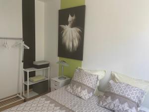 a bedroom with a bed with two pillows and a picture at Les Terrasses des Gardies in Pignan