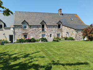 a large stone house with a grass yard at Le Manoir de la Pichardière in Cherrueix