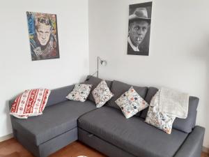 a living room with a gray couch with pillows at Le Blason du Poête in Mayet