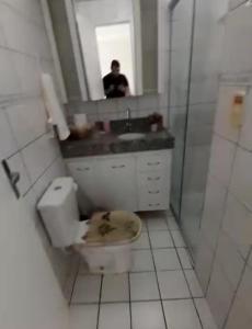 uma casa de banho com um WC, um lavatório e um espelho. em Crystal Park Flat em Aquiraz