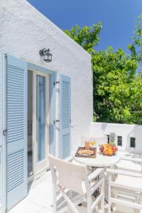 a patio with white chairs and a table with food on it at Agia Anna Living in Agia Anna Naxos