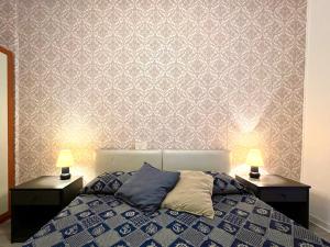 a bedroom with a bed and two night stands with lamps at Hotel Alemagna in Bibione