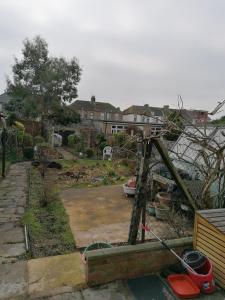 een uitzicht op een tuin met een huis bij Single Bedroom available - Train station London Seven Kings in Seven Kings