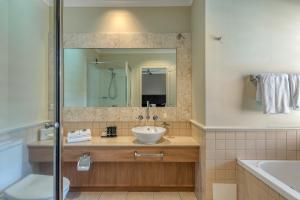 La salle de bains est pourvue d'un lavabo et d'un miroir. dans l'établissement Magnificent 2 bed unit in heart of Port Douglas, à Port Douglas