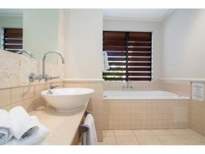 La salle de bains est pourvue d'un lavabo et d'une baignoire. dans l'établissement Magnificent 2 bed unit in heart of Port Douglas, à Port Douglas