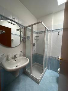 La salle de bains est pourvue d'un lavabo et d'une douche. dans l'établissement Hotel Alemagna, à Bibione