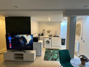 a living room with a tv and a kitchen at Luxury Studio Apartment in Harrow on the Hill