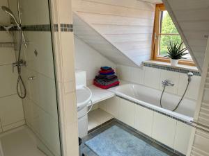 uma casa de banho com um chuveiro, uma banheira e um lavatório. em Bergblick em Weilheim in Oberbayern