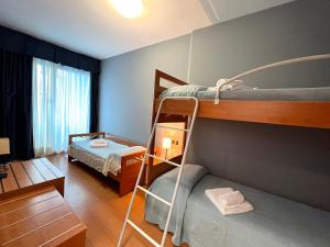Zimmer mit 2 Etagenbetten und einem Schreibtisch in der Unterkunft Hotel Alemagna in Bibione