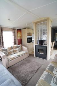 a living room with a couch and a fireplace at Manor at Manor Park Hunstanton WiFi pets go free in Hunstanton