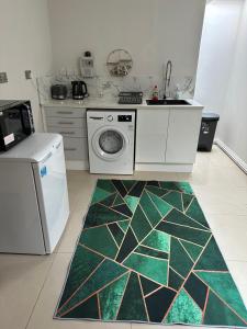 a kitchen with a sink and a washing machine at Luxury Studio Apartment in Harrow on the Hill