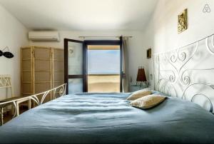 1 dormitorio con 1 cama grande con manta azul en Corbezzolo, en Funtana Meiga