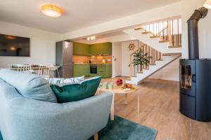 un soggiorno con un divano blu e una scala di Ostoja Lubiatowo a Lubiatowo