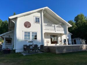 a white house with a table and chairs in front of it at Stunning Tiny House Tree of Life at lake Skagern in Finnerödja