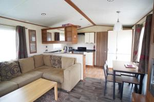 een woonkamer en een keuken met een bank en een tafel bij Manor at Manor Park Hunstanton WiFi pets go free in Hunstanton