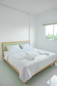 a white bed with two white bows on it at S1 Trang Hotel in Trang