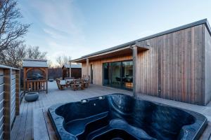 a hot tub on the deck of a house at Húsafell holiday homes in Húsafell