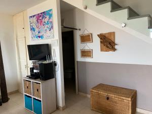 a living room with a staircase and a television at Corbezzolo in Funtana Meiga